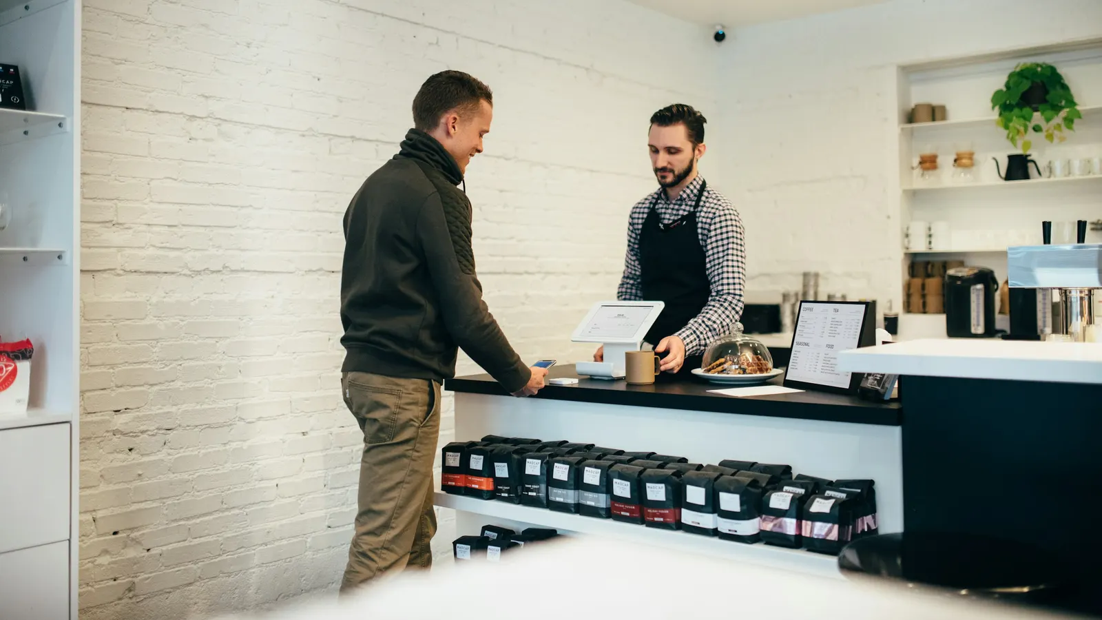 Customer buying from a staff member at a retail shop counter